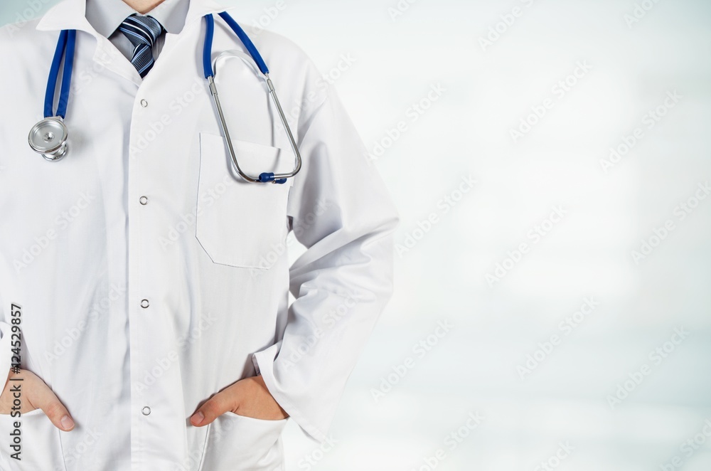 Doctor with hands in pocket on blurred background. Copyspace medical concept Doctor with hands in pocket on blurred background. Copyspace medical concept