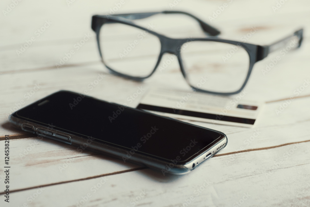 Eyeglasses, mobile phone and credit card. Eyeglasses, mobile phone and credit card.