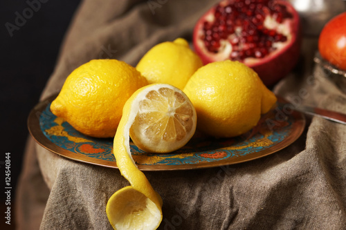 Beautiful lemons on a plate, one cut skin.
