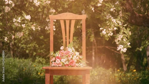 Vintage chair and flowers under blossoming appletree