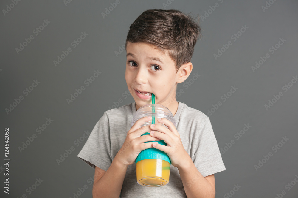 Little funny boy drinking a fresh juice through a straw Little funny boy drinking a fresh juice through a straw