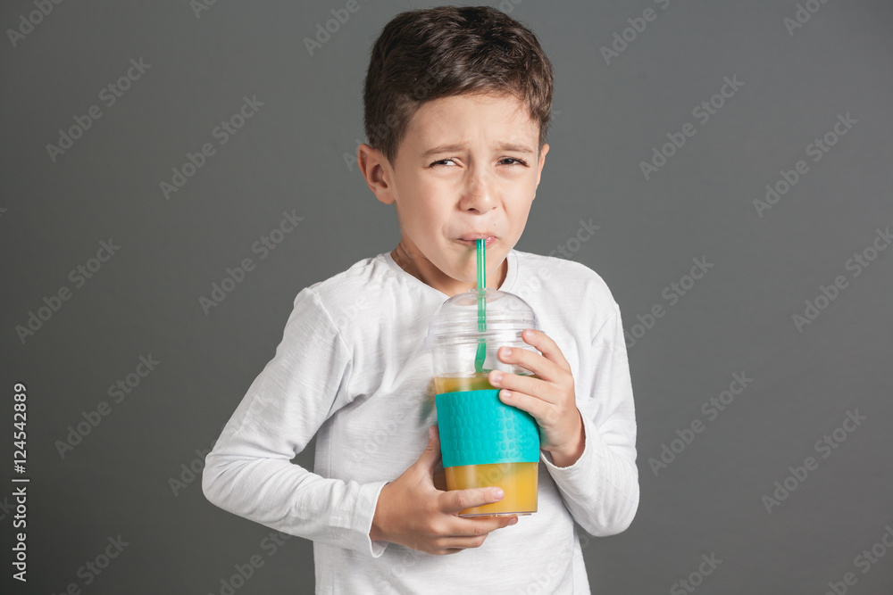 Little funny boy drinking a fresh juice through a straw Little funny boy drinking a fresh juice through a straw