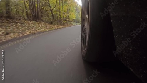 Schnelles Auto fährt auf Landstraße durch einen Wald