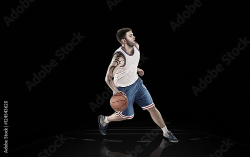 Caucasian basketball player with ball isolated on a black background