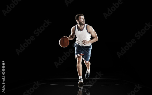 Strong basketball player in action isolated on black background