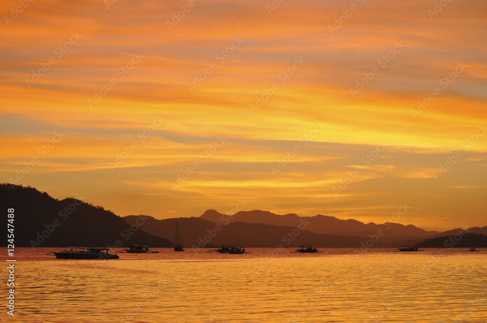 Sunset red sky on Coron city in the Philippines with a few tipic boat on the foreground