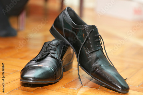 men leather black shoes on wooden floor