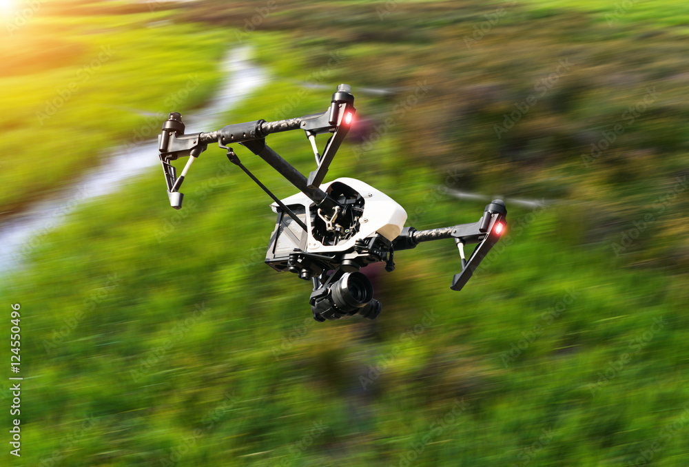 Drone flying above green field Photos | Adobe Stock