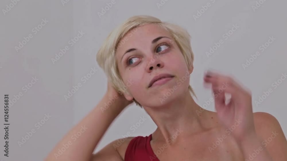 Pretty, young and blonde woman in red dress without make-up fixing hair. Natural beauty concept Pretty, young and blonde woman in red dress without make-up fixing hair. Natural beauty concept