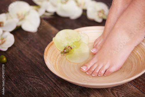 Manicured female feet in spa pedicure procedure