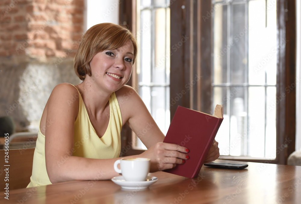 pretty woman enjoying reading book at coffee shop drinking cup of coffee or tea smiling happy pretty woman enjoying reading book at coffee shop drinking cup of coffee or tea smiling happy