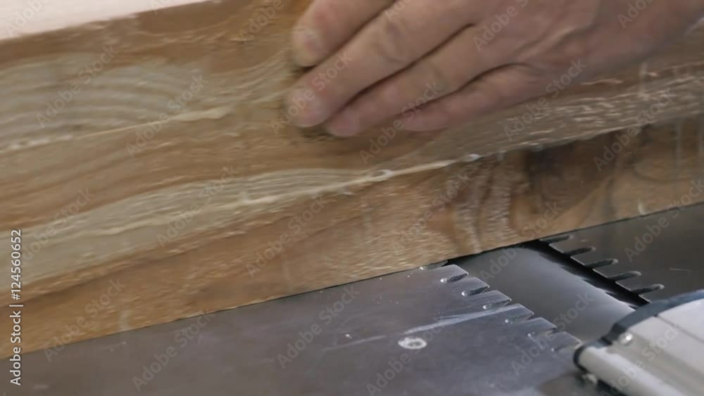 Man Using a Table Saw to cut wood, grinding on modern furniture factory Man Using a Table Saw to cut wood, grinding on modern furniture factory
