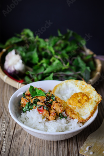 Stir Fried Basil Cicken with Rice and Egg on wooden, Thai Famous