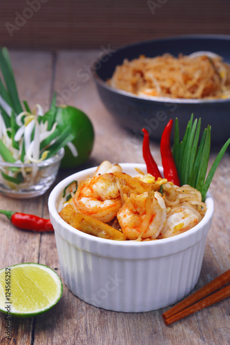 Famous traditional thai food shrimp pad thai, rice noodle stir-fry with prawns, tofu and vegetables on white bowl.