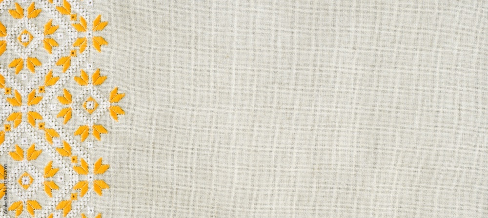Embroidery design by yellow and white cotton threads on flax
