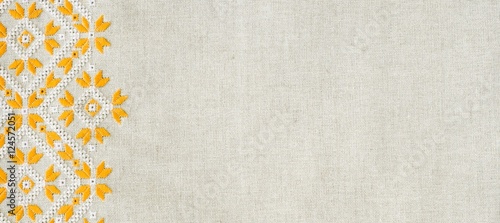 Embroidery design by yellow and white cotton threads on flax. Background with embroidery for banner.