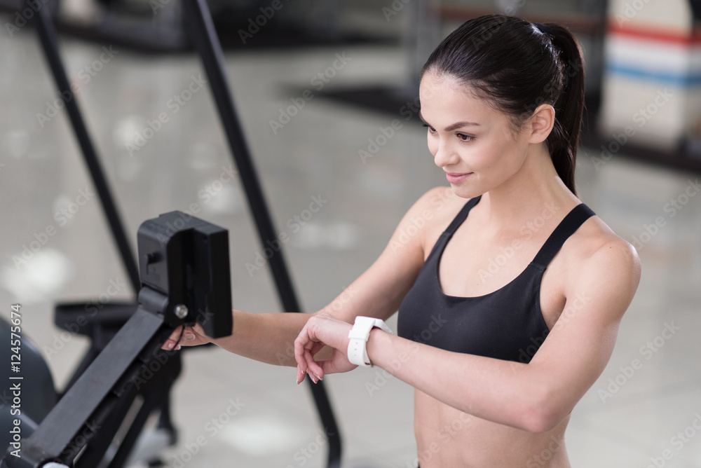 Young woman using scales and smart watch in a gym Young woman using scales and smart watch in a gym