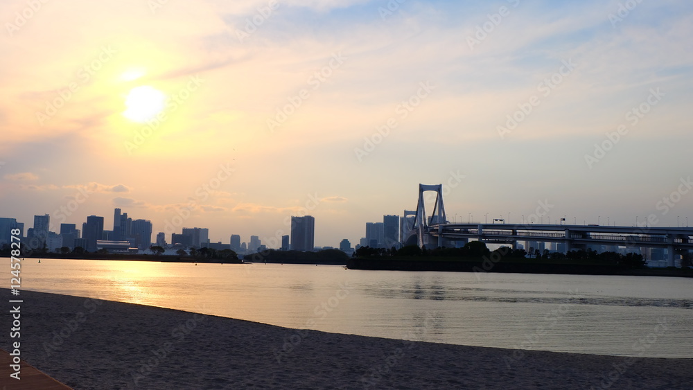 Seaside at Odaiba with orange sun and cloudy sky in late afternoon, Tokyo, Japan.