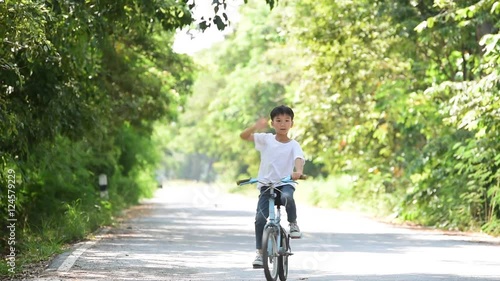 Wallpaper Mural Young Thai boy ride bicycle hand on the road in the park. Torontodigital.ca