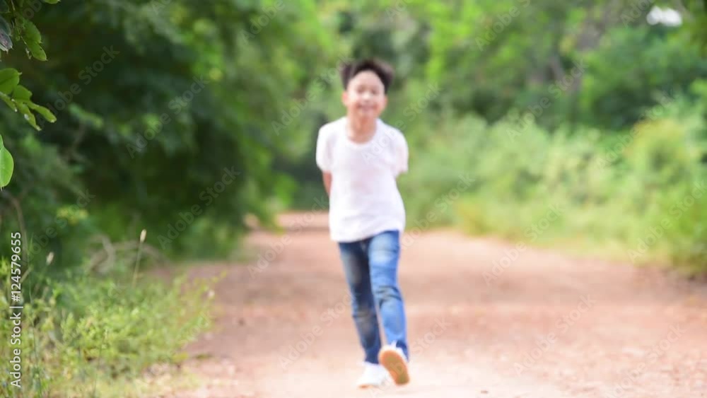 Slow motion young Thai boy run together on the crack road in the natural park. Slow motion young Thai boy run together on the crack road in the natural park.
