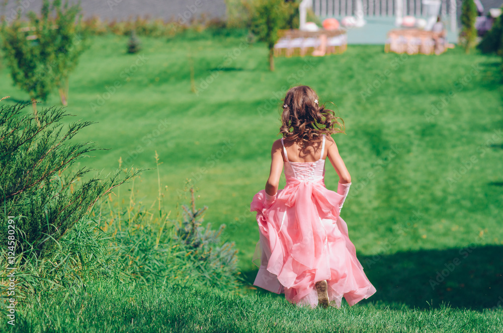 Girl running along a field at sunset