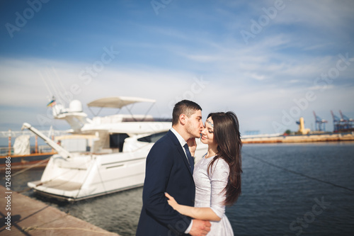 Happy wedding couple hugging near new yacht © olegparylyak