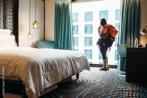 Woman backpacker traveler stay in high quality hotel room photo