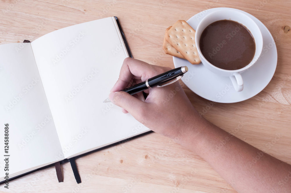 Writing in blank book on wooden table Writing in blank book on wooden table
