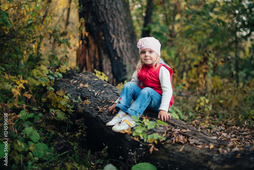 little girl in the red in the autumn forest, park
