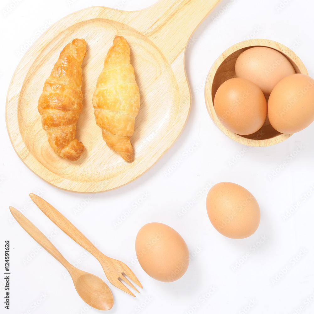 Double croissants and fresh eggs with wooden ware Double croissants and fresh eggs with wooden ware