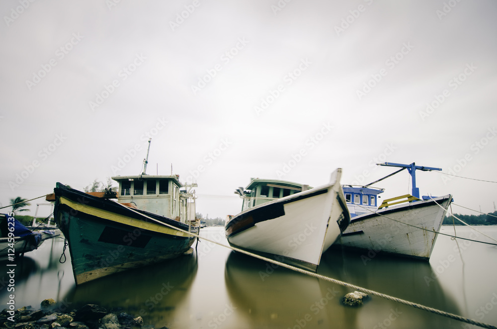 anchored fisherman boat. soft look on water with boat reflection anchored fisherman boat. soft look on water with boat reflection