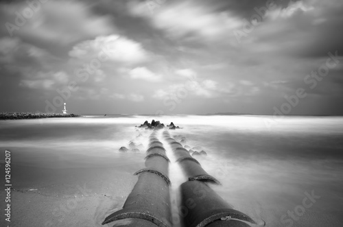 black and white,image of concrete drain pipeline at coastline. s