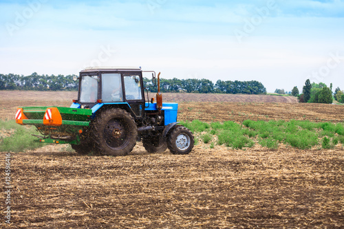 Rural landscape with old tractor in a field sow seed.