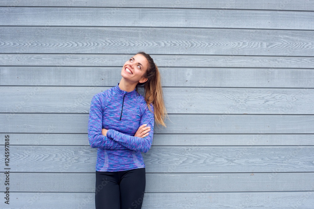 Happy woman in workout clothes looking up Happy woman in workout clothes looking up