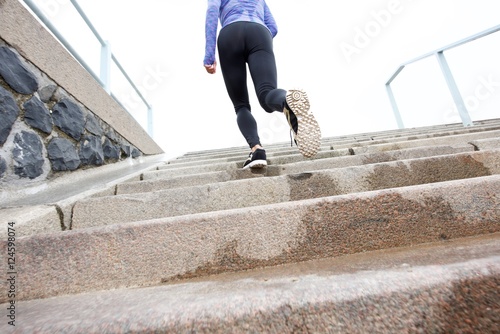 Female runner on wet staircase outside