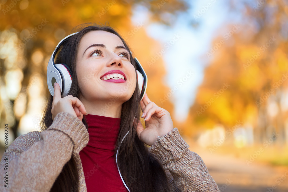 Autumn portrait of happy woman with headphones in park Autumn portrait of happy woman with headphones in park