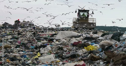 Bulldozer flattening garbage in a landfill waste site