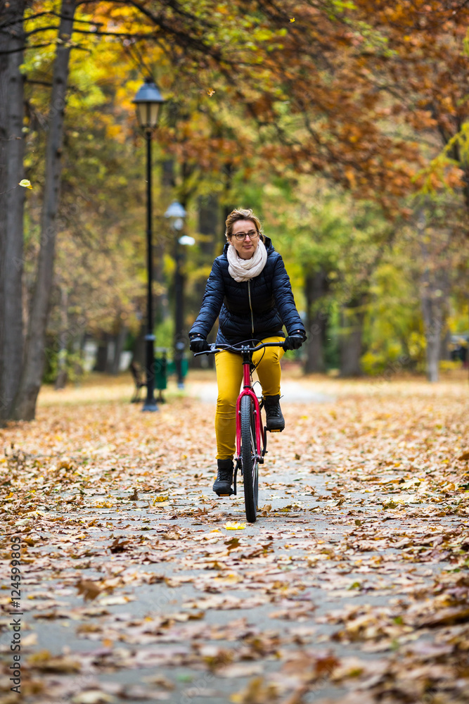 Urban biking - woman riding bike in city park Urban biking - woman riding bike in city park