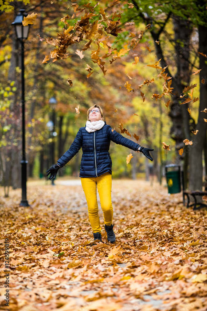 Middle-aged woman walking in city park Middle-aged woman walking in city park