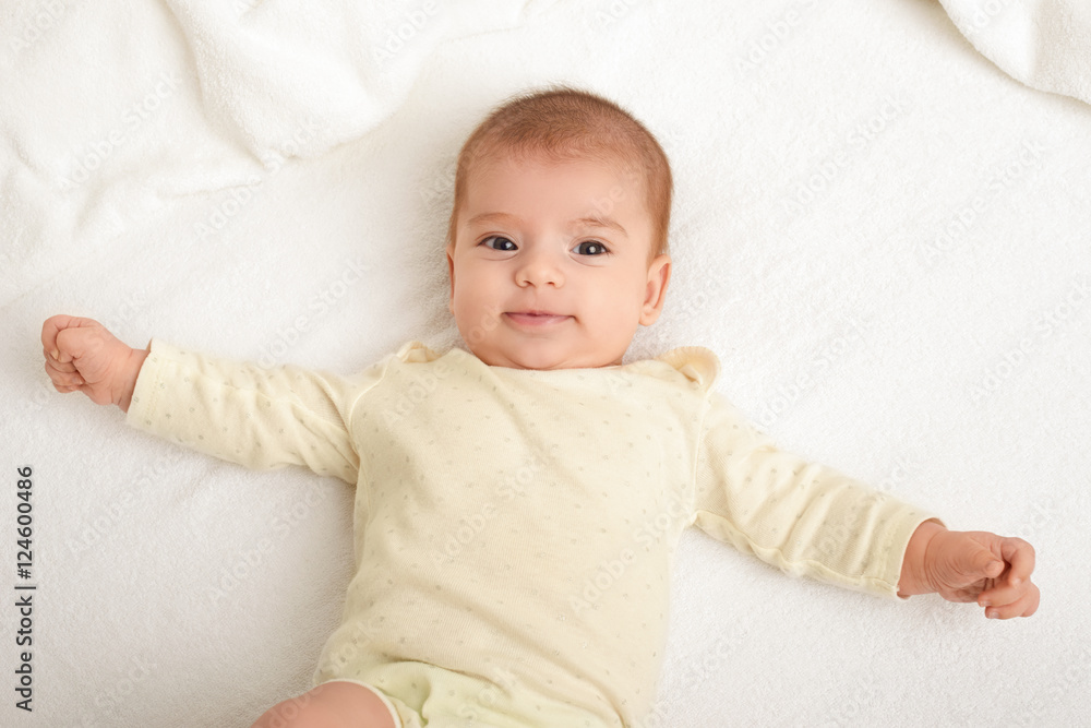 baby portrait lie on white towel in bed, yellow toned baby portrait lie on white towel in bed, yellow toned