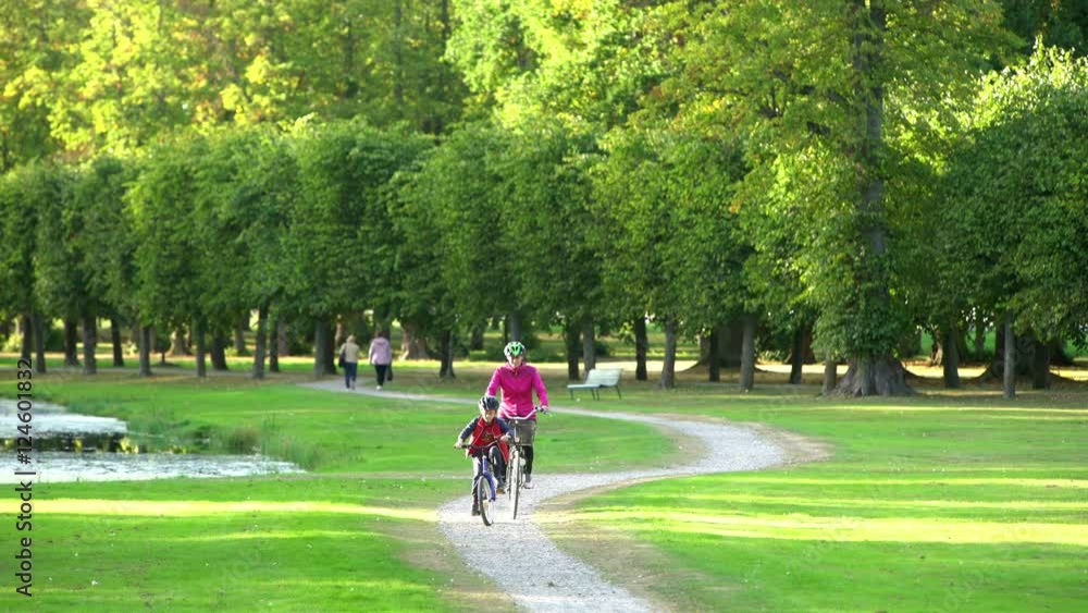 A mother and her son cycling through a park in Stockholm, Sweden A mother and her son cycling through a park in Stockholm, Sweden