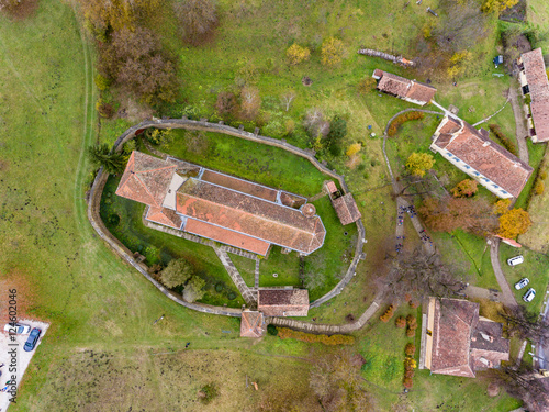 Fortified walled church in the traditional saxon village Malancrav, Transylvania, Romania. Aerial view from a drone.