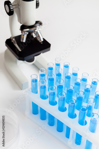 tubes with liquid and microscope on white background