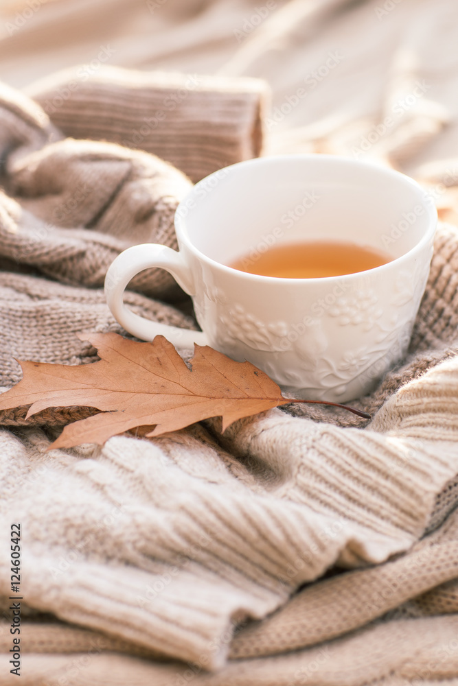 Warm knitted sweater,cup of hot tea and red thermos Warm knitted sweater,cup of hot tea and red thermos