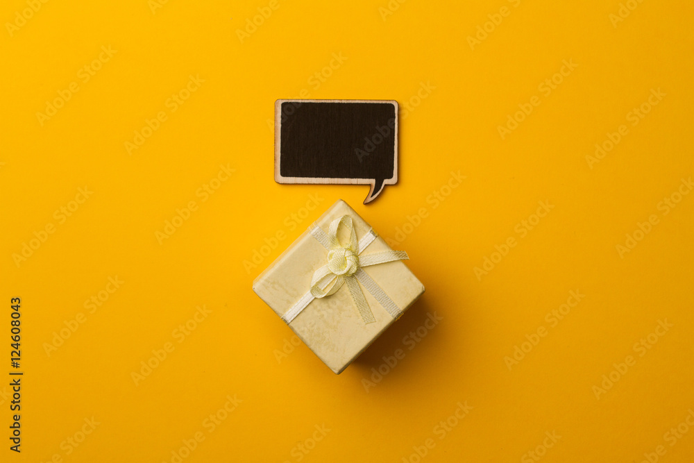 Concept little gift box with wooden speech bubble for messages Concept little gift box with wooden speech bubble for messages