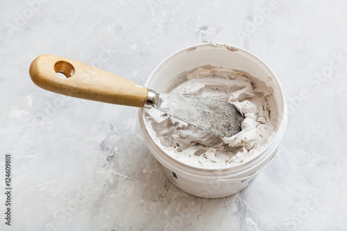 metal spatula in pot with putty