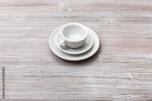 one white cup with saucers on gray brown board