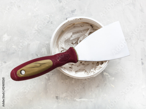 Obraz na płótnie metal spatula on container with putty