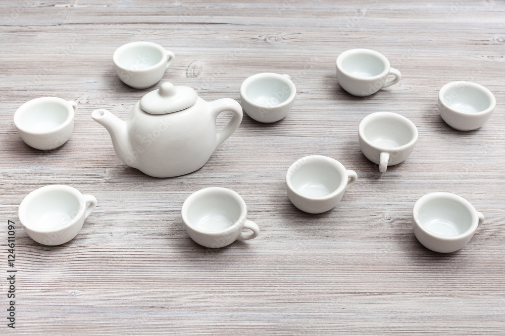 white ceramic cups and teapot on gray brown table white ceramic cups and teapot on gray brown table