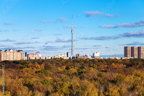 autumn landscape with woods and city with tv tower photo